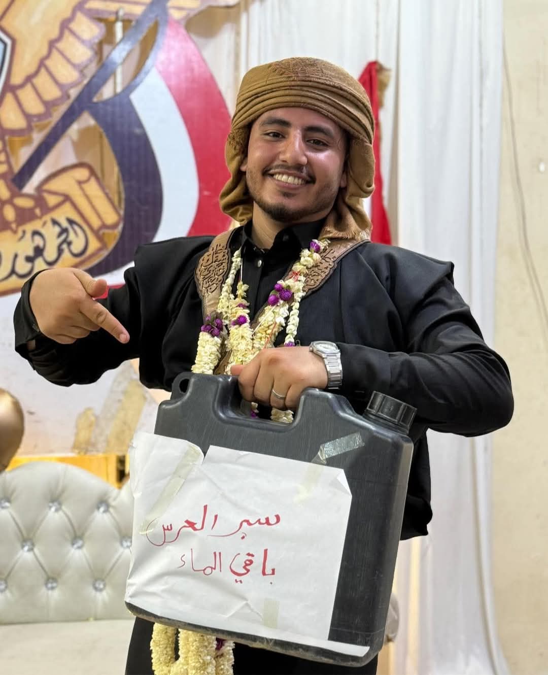 شاب في تعز يحتفل بزواجه حاملا جالون مكتوب عليه "سبر العرس باقي الماء"